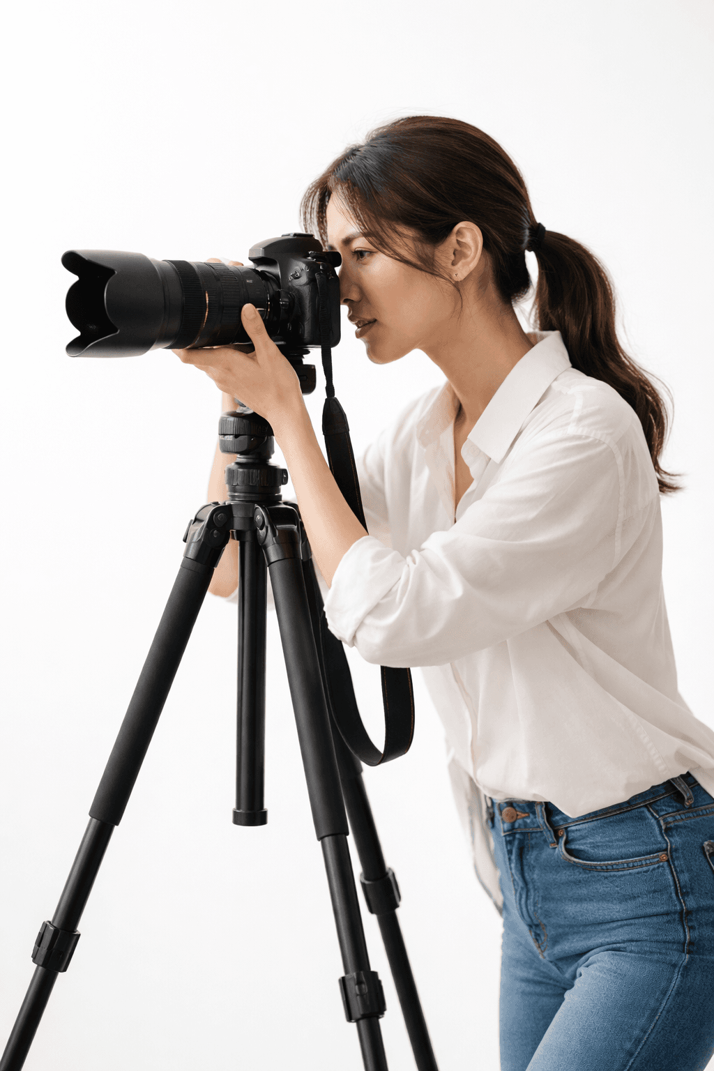 Photographer looking through a camera on a tripod